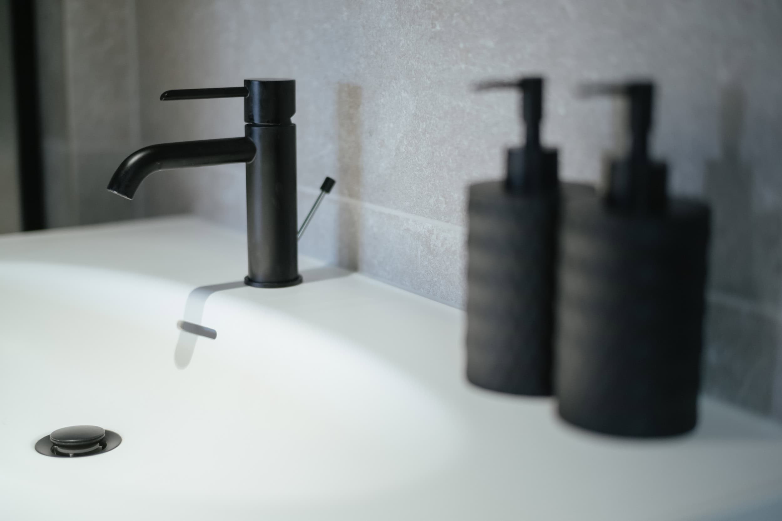 close up of basin with black brassware